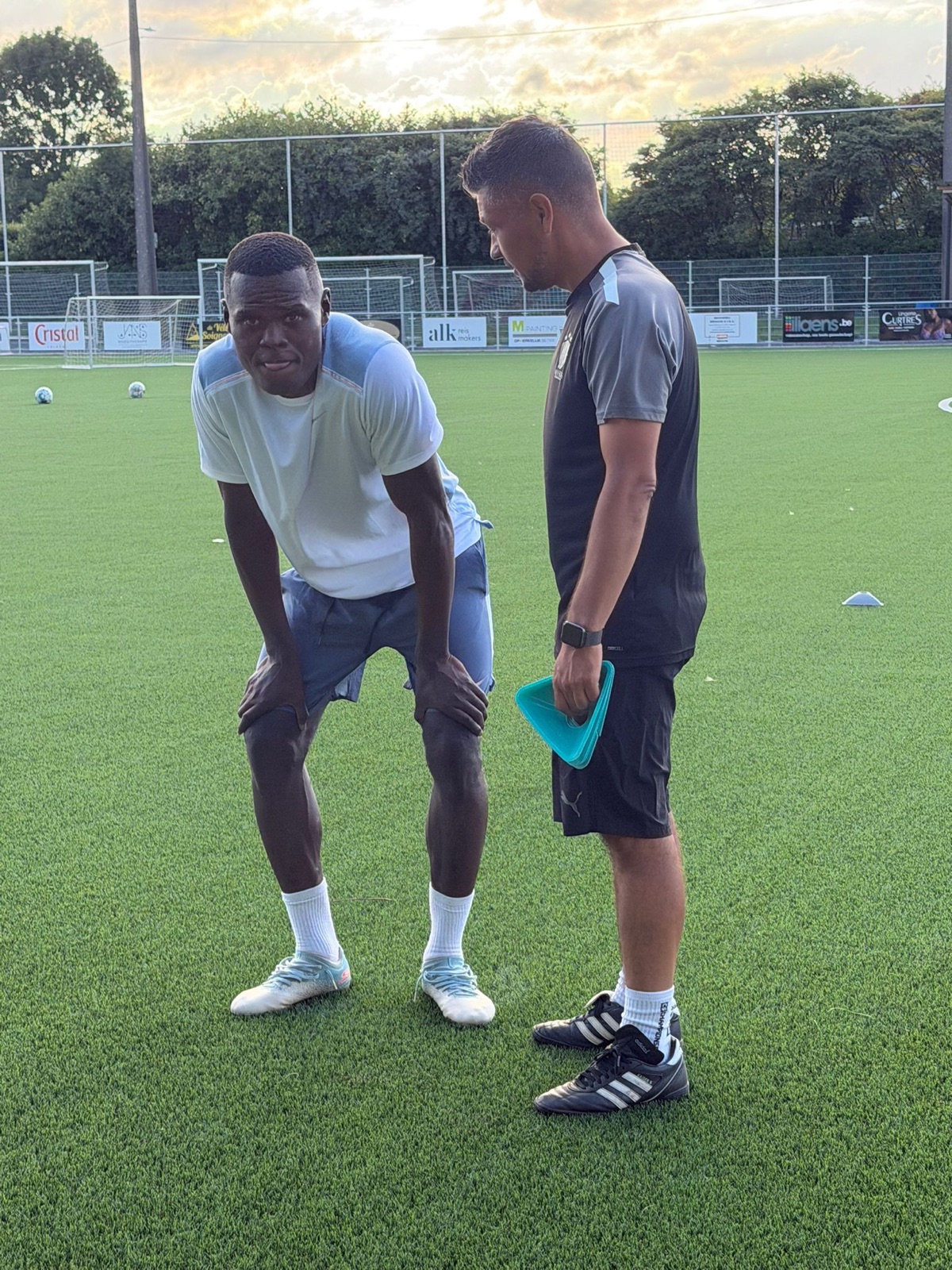 Coach Manu Larose in gesprek met een speler tijdens de training